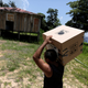 An electoral worker carries an electronic ballot box to a house close to the Amazon River.